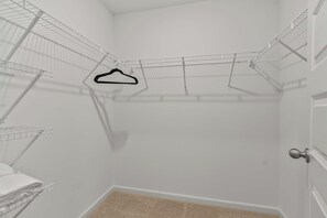 A corner laundry room with metal drying racks and a door. - The Garden Villa | Tuscaloosa Retreat Sleeps 8 (Tuscaloosa)