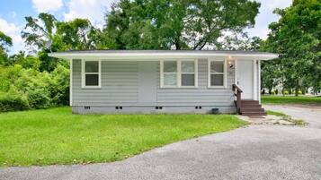 A single-story house with a front porch, a small front yard, and a driveway.