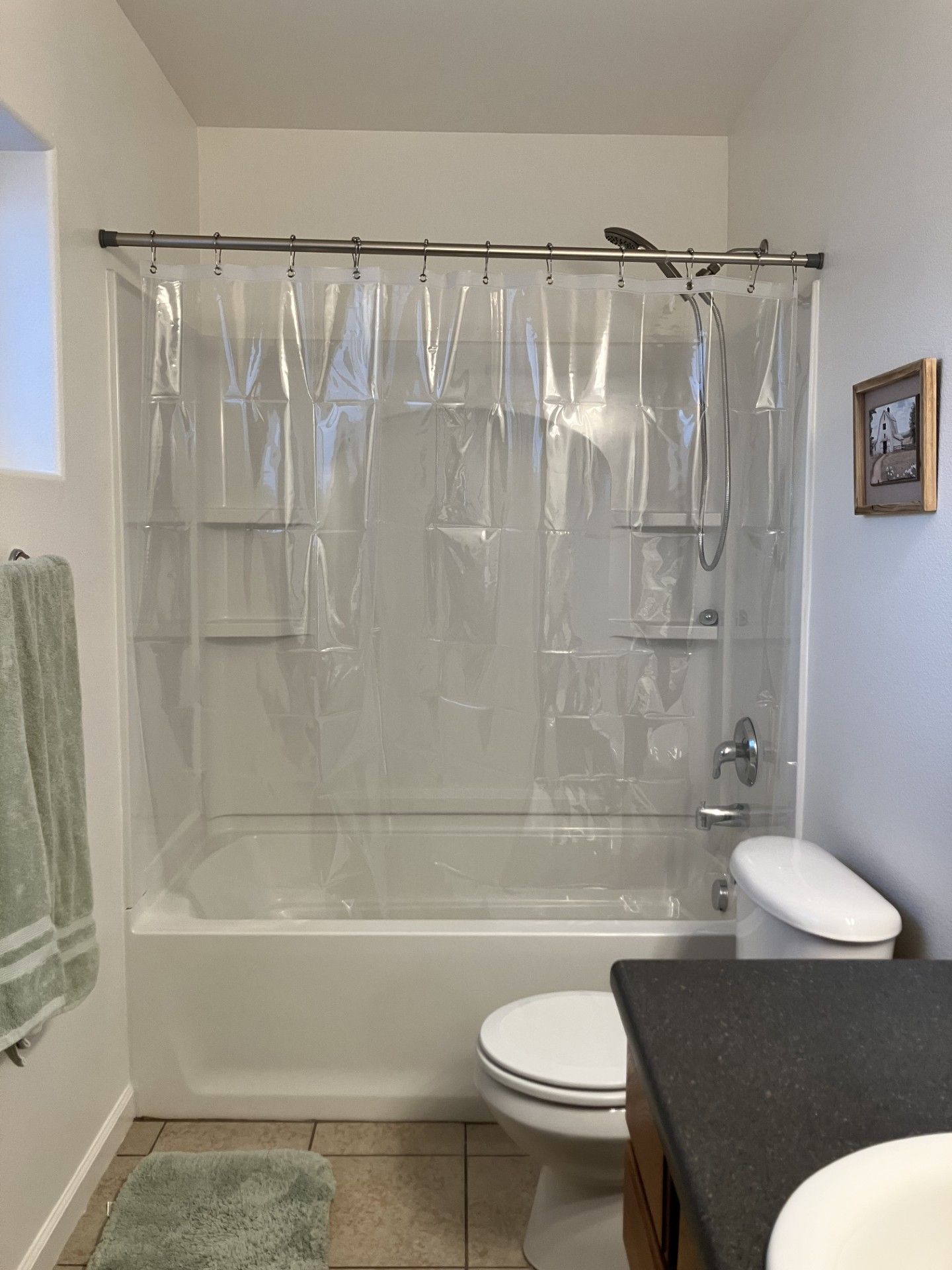 A bathroom with a bathtub, toilet, and shower curtain.