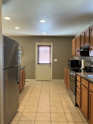 A kitchen with a refrigerator, oven, microwave, and wooden cabinets. - Welcome to the Bradish house! (La Junta)