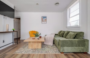 A modern living room with a green sofa, a wooden coffee table, and a yellow armchair. - Bright 2BR with Washer/Dryer, & Dedicated Parking in beautiful Petersburg (Petersburg)