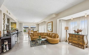 A spacious living area with a leather sofa, a glass coffee table, and a wooden sideboard. - Waterfront Luxury 2 BR Ground Floor St. Augustine FL (St. Augustine)