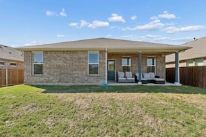 A single-story brick house with a covered patio area. - Riverfront Denton Retreat | Spacious 4BR (Denton)