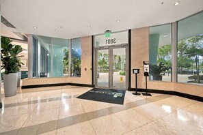 A hotel lobby with a glass entrance, a digital keycard reader, and a large potted plant. - Modern 2-bedroom apartment at the Tides Beach (Hollywood)