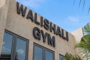 A building with the sign 'WALISHALI GYM' indicating a gym facility. - Walk-Out to Pool |Jacuzzi, BBQ & White Sand Lounge (Noord)