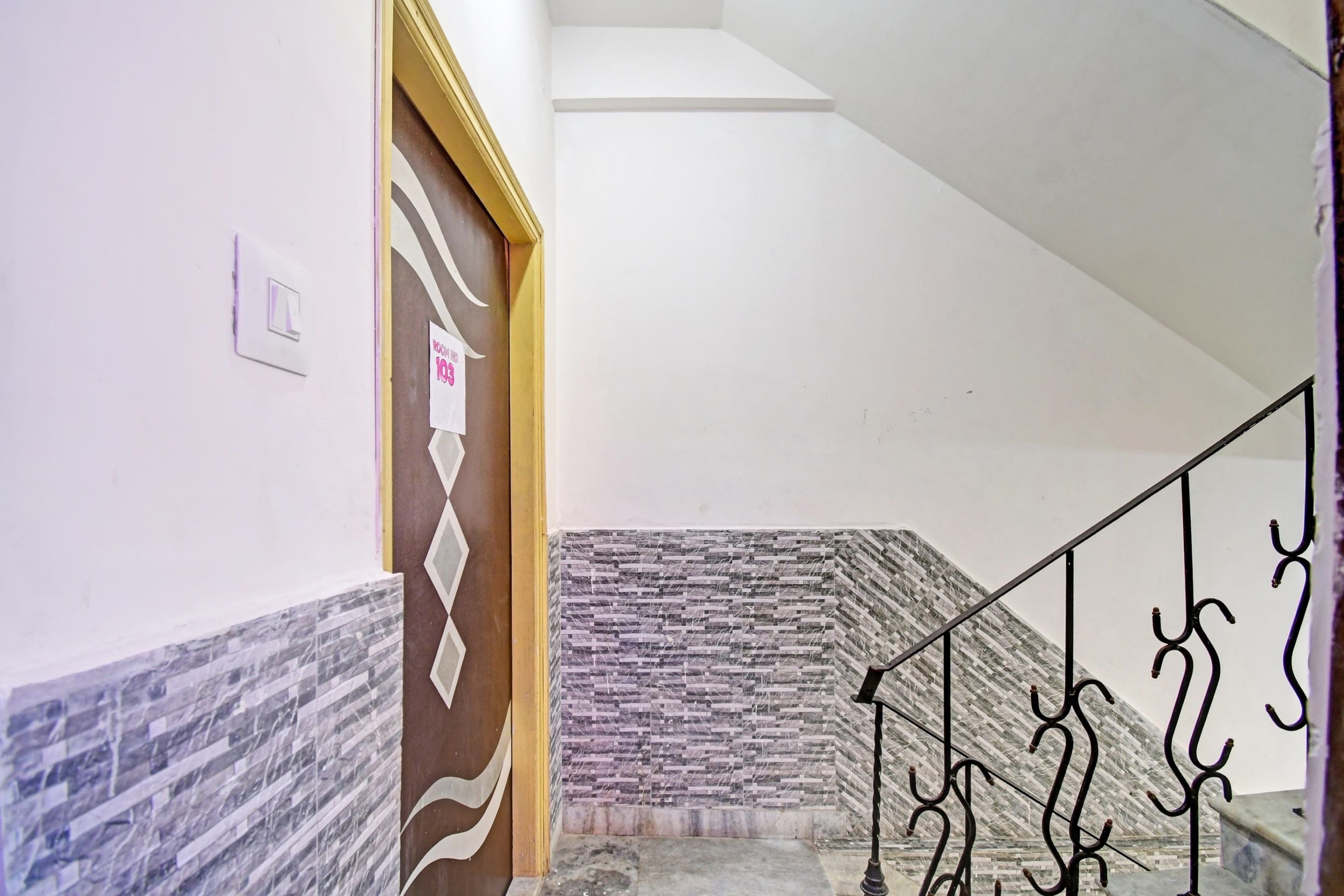 A staircase with a patterned wall and a metal railing.