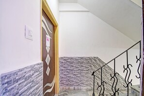A staircase with a patterned wall and a metal railing.