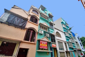 Un edificio de varios pisos con varios letreros, incluyendo uno para Diamond Residency Guest House.