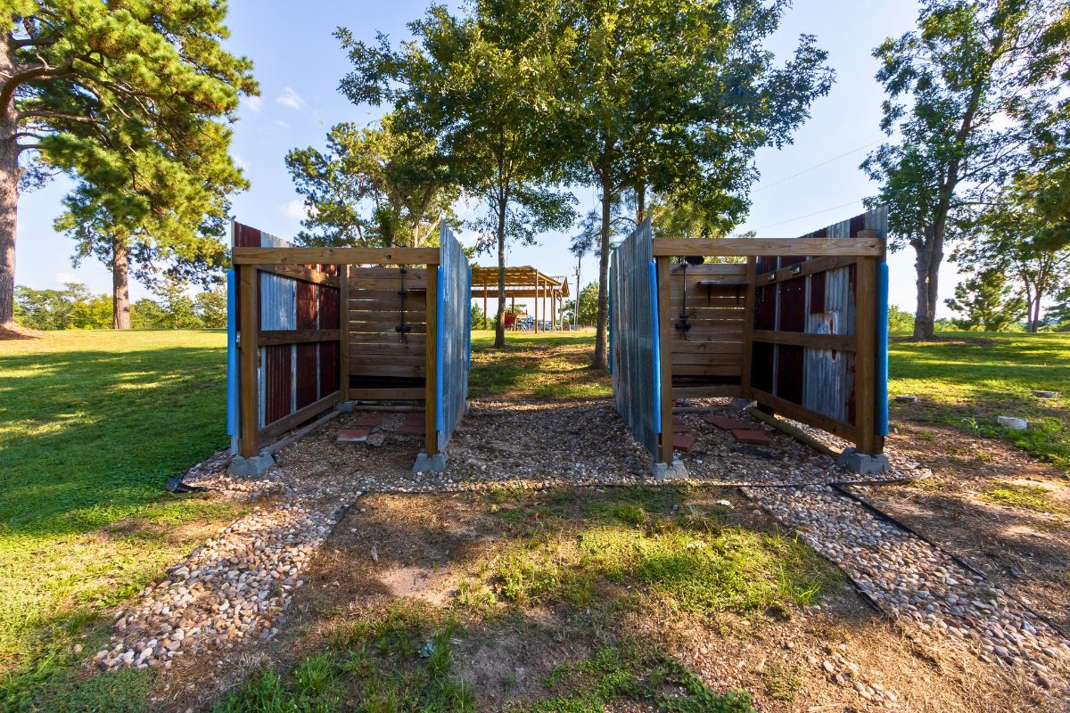 Une structure de pergola en bois avec un espace salon couvert en arrière-plan.