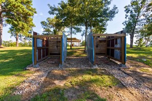 Una pergola in legno con un'area salotto coperta sullo sfondo.