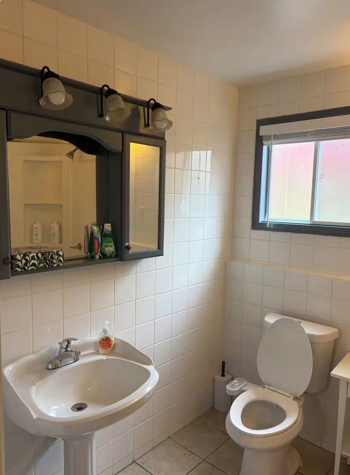 A bathroom with a sink, mirror, and toilet.