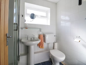 Ein Badezimmer mit Waschbecken, Toilette und Duschkabine aus Glas.