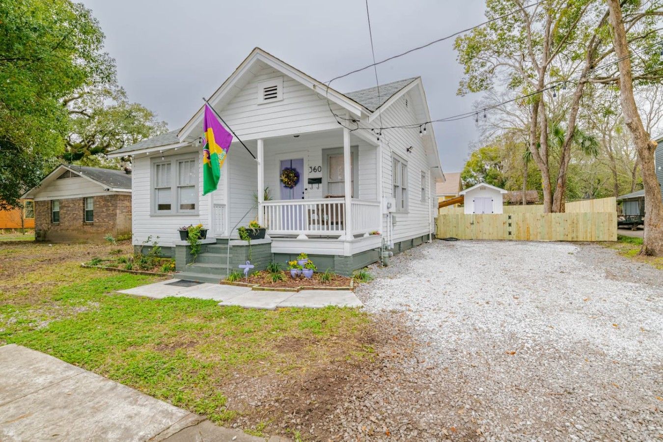 A single-story house with a porch, a mailbox, and a number '360' on the front door.