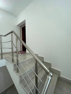 A modern staircase with a metal handrail and marble steps. - Dar Kmar Djerba Midoun  (Djerba Midun)