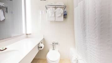 Un baño moderno con inodoro, toallero y espejo.