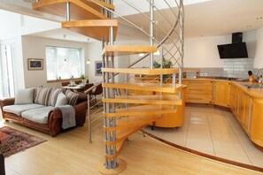 A modern kitchen with wooden cabinets and a built-in stove. - The Gallery, Tenby - Two Bedroom Cottage, Sleeps 4 (Tenby)