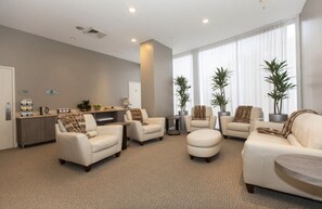 A spacious living area with multiple seating options, a reception desk, and large windows providing natural light. - ★★★★★ Golden Horizon Luxury Beach Studio (Sunny Isles Beach)