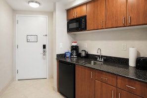 A compact kitchen with wooden cabinets, a microwave, a coffee maker, and a sink. - ★★★★★ Golden Horizon Luxury Beach Studio (Sunny Isles Beach)