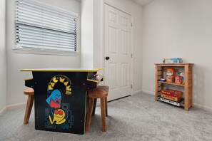 A room with a small desk featuring a cartoon character, a door, and a shelf with cereal boxes. - The Golden Cricket -PointeRoyale (Branson)