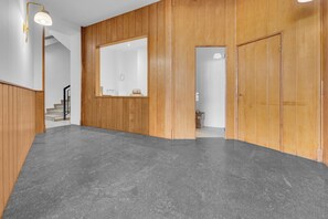 A hallway with wooden paneling, a large mirror, and a grey floor. - 4 Finestre sul duomo (Milan)