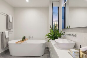 A modern bathroom with a freestanding bathtub, a sink, and a mirror. - NovaStar Test Hotel 0l3aex (Sedalia)