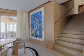 A modern interior with a staircase, a dining area, and a large painting on the wall. - Villa Fenix by My Villa Collection (Forio d'Ischia)
