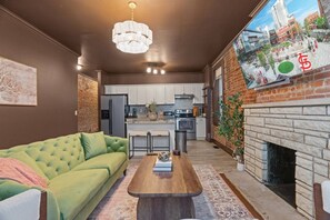 Una sala de estar moderna con un sofá verde, una mesa de centro de madera y una chimenea.