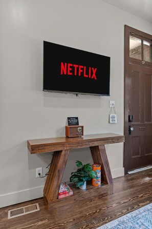 Ein an der Wand befestigter Fernseher, auf dem 'NETFLIX' angezeigt wird.