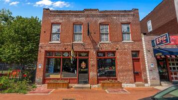 A brick building with a storefront featuring a pizza sign and a flag.