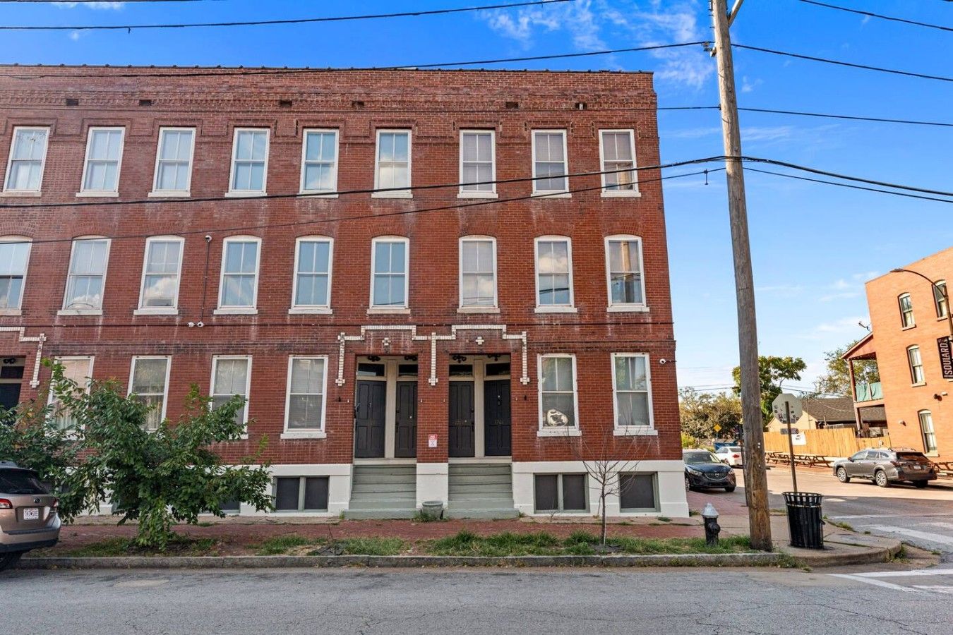 A red brick building with multiple windows and a central entrance.