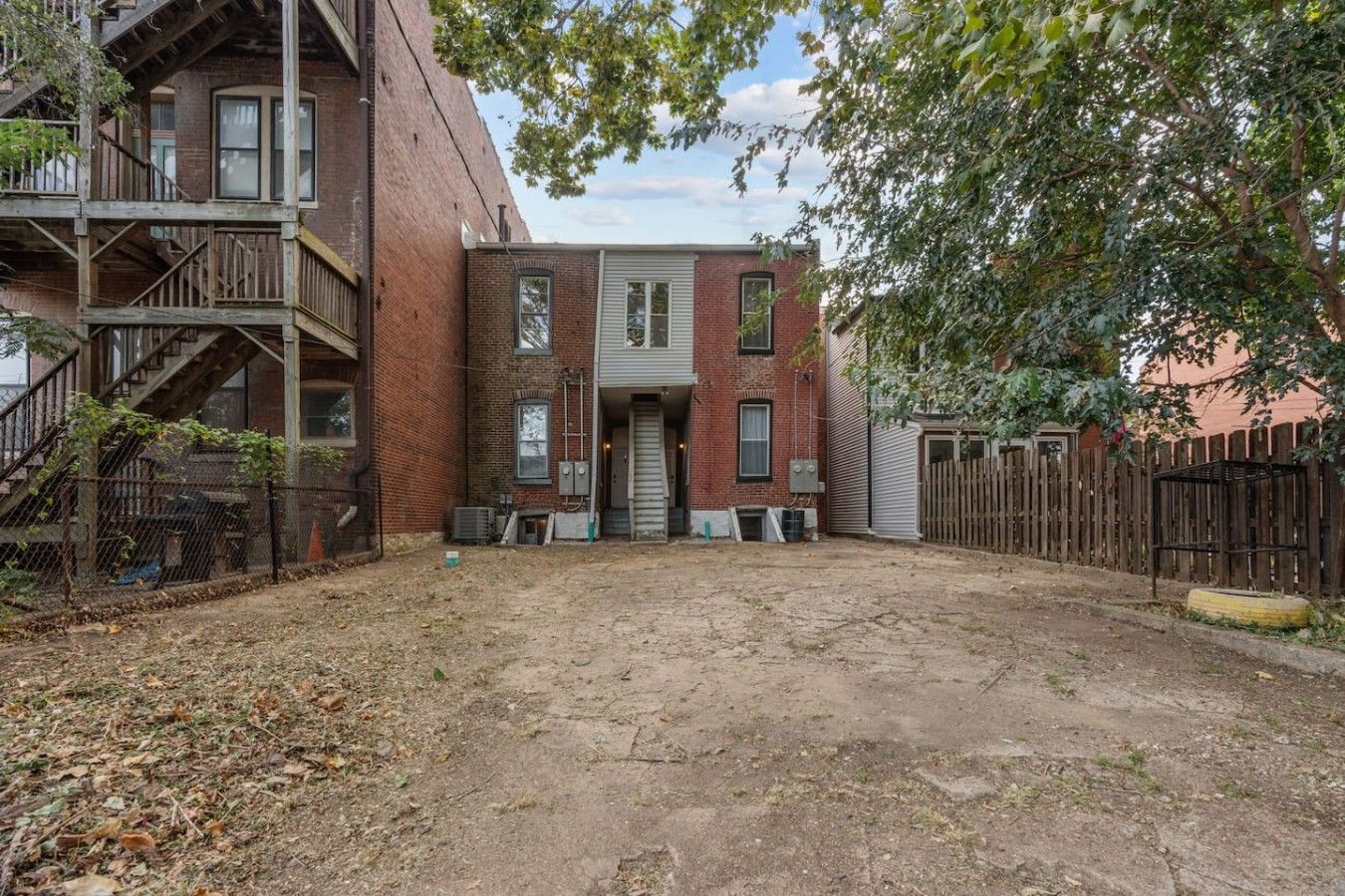 A two-story brick building with a front door and a small front yard.