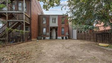 A two-story brick building with a front door and a small front yard.