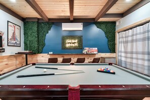 A pool table with chairs, a neon sign, and a poster on the wall. - Smoky Mtn Escape | Hot Tub • Fire Pit • Game Room (Gatlinburg)
