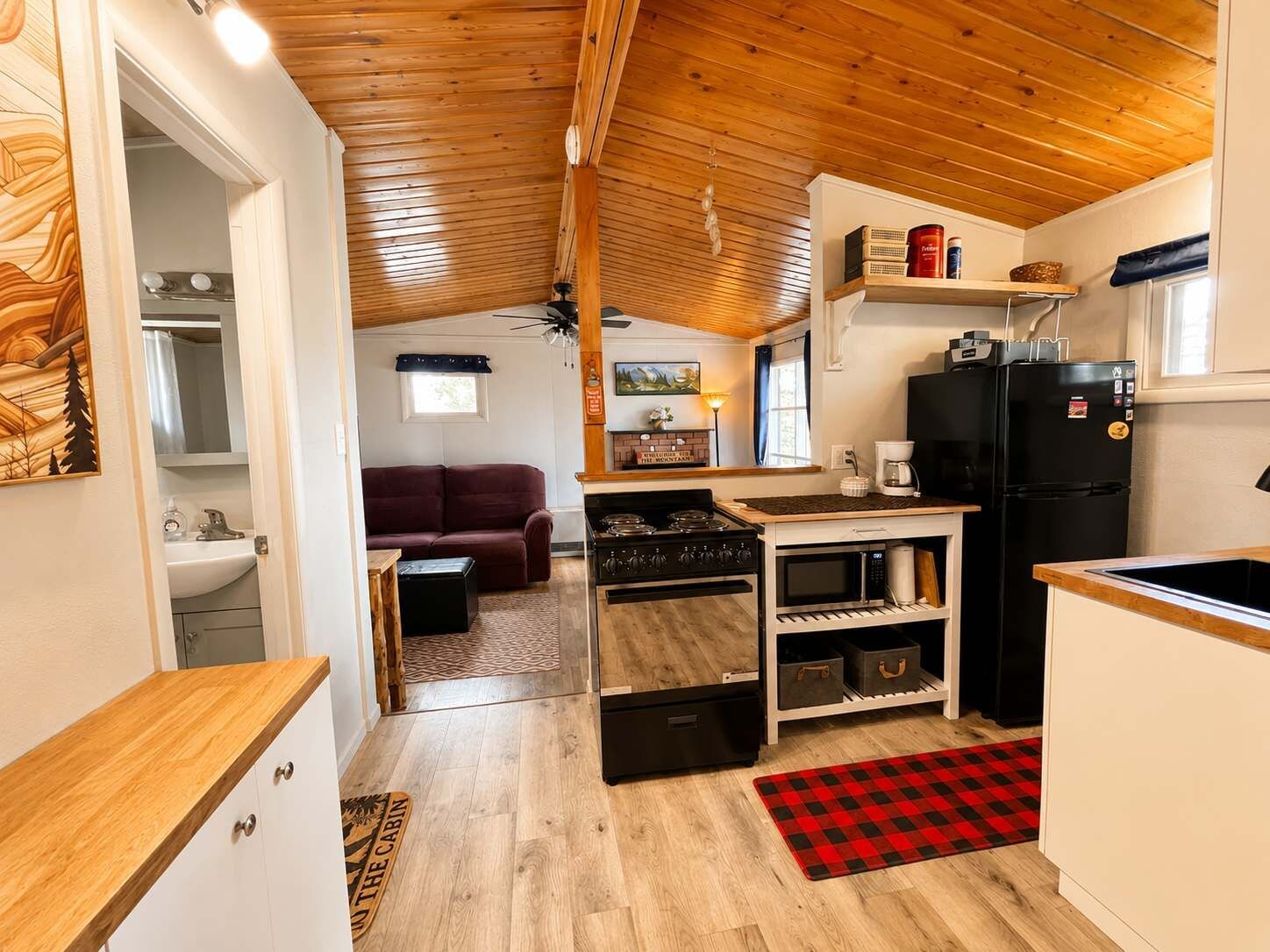 A compact kitchen with a stove, microwave, and refrigerator.