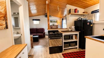 A compact kitchen with a stove, microwave, and refrigerator.