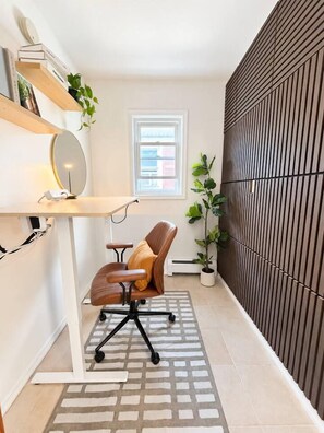 A modern office space with a desk, chair, shelving, and a potted plant. - A Rare, Spacious Retreat - Downtown JC, Free Parking, Close to PATH (Jersey City)