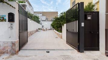 A gated entrance to a property with a tiled pathway leading to a building.