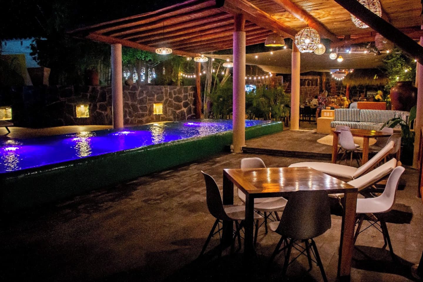An outdoor patio with a stone wall, a water feature, and seating arrangements.
