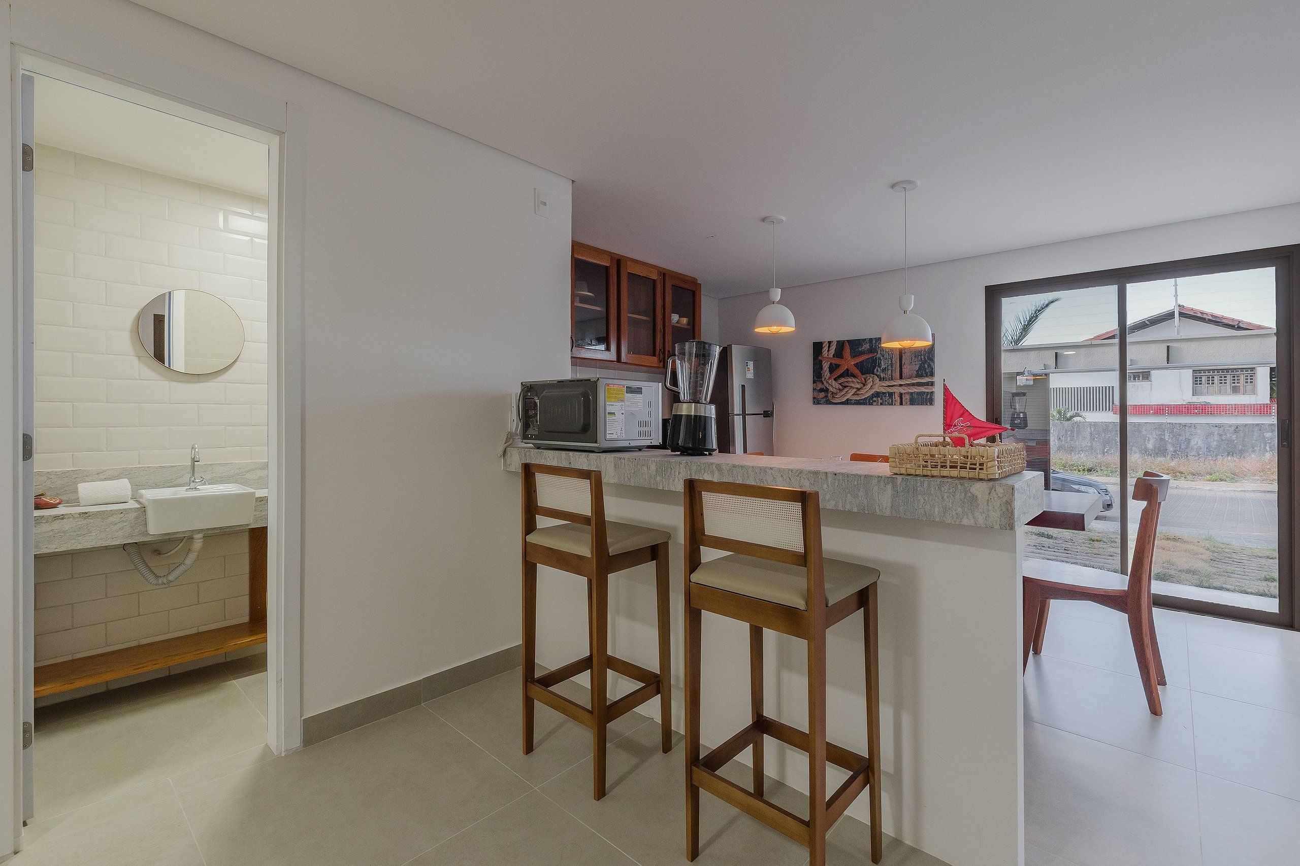 A kitchen with a built-in microwave, a coffee maker, and a large window.