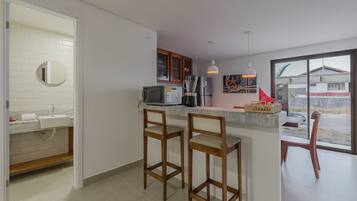 A kitchen with a built-in microwave, a coffee maker, and a large window.