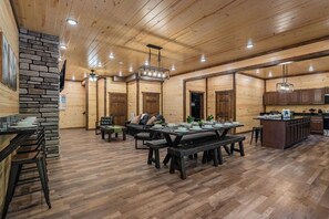 Un intérieur spacieux en bois, comprenant un coin repas, un canapé et une cuisine.