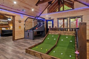 Un intérieur en bois comprenant une table de billard, une table de snooker et un petit escalier.