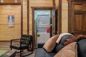 A wooden interior with a sofa, a chair, and a television. - New Luxury Lodge • Private Pool • Hot Tub • Game Room • Sleeps 18 (Sevierville)