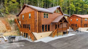 A log cabin with a porch, a staircase, and a deck. - Brand-New Luxury Cabin • Private Pool • Game Room • Sleeps 18 (Sevierville)