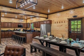 L’intérieur d’un chalet en bois comprend une cuisine, un coin repas et une grande fenêtre.