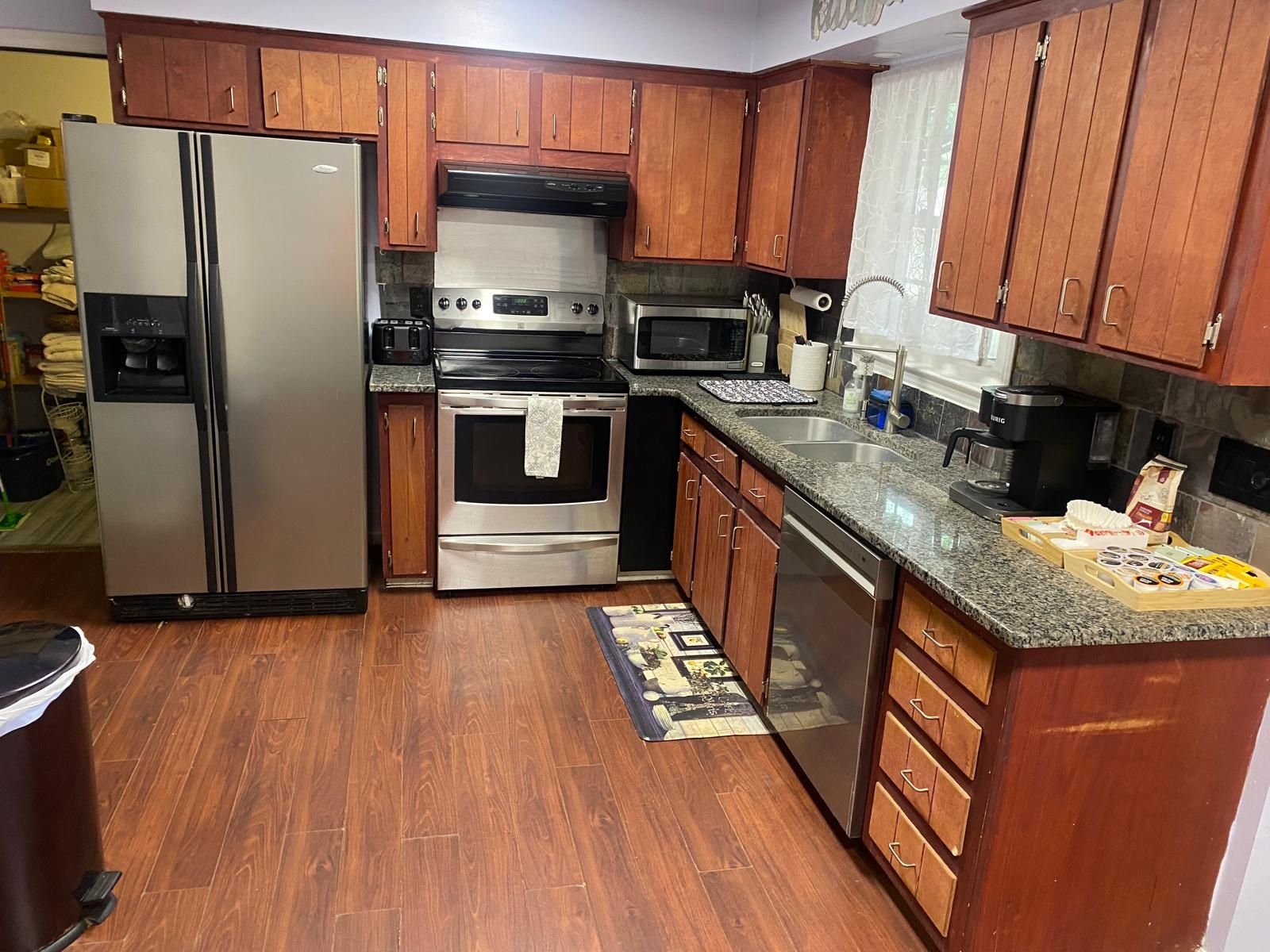 A kitchen with wooden cabinets, stainless steel appliances, and a granite countertop.