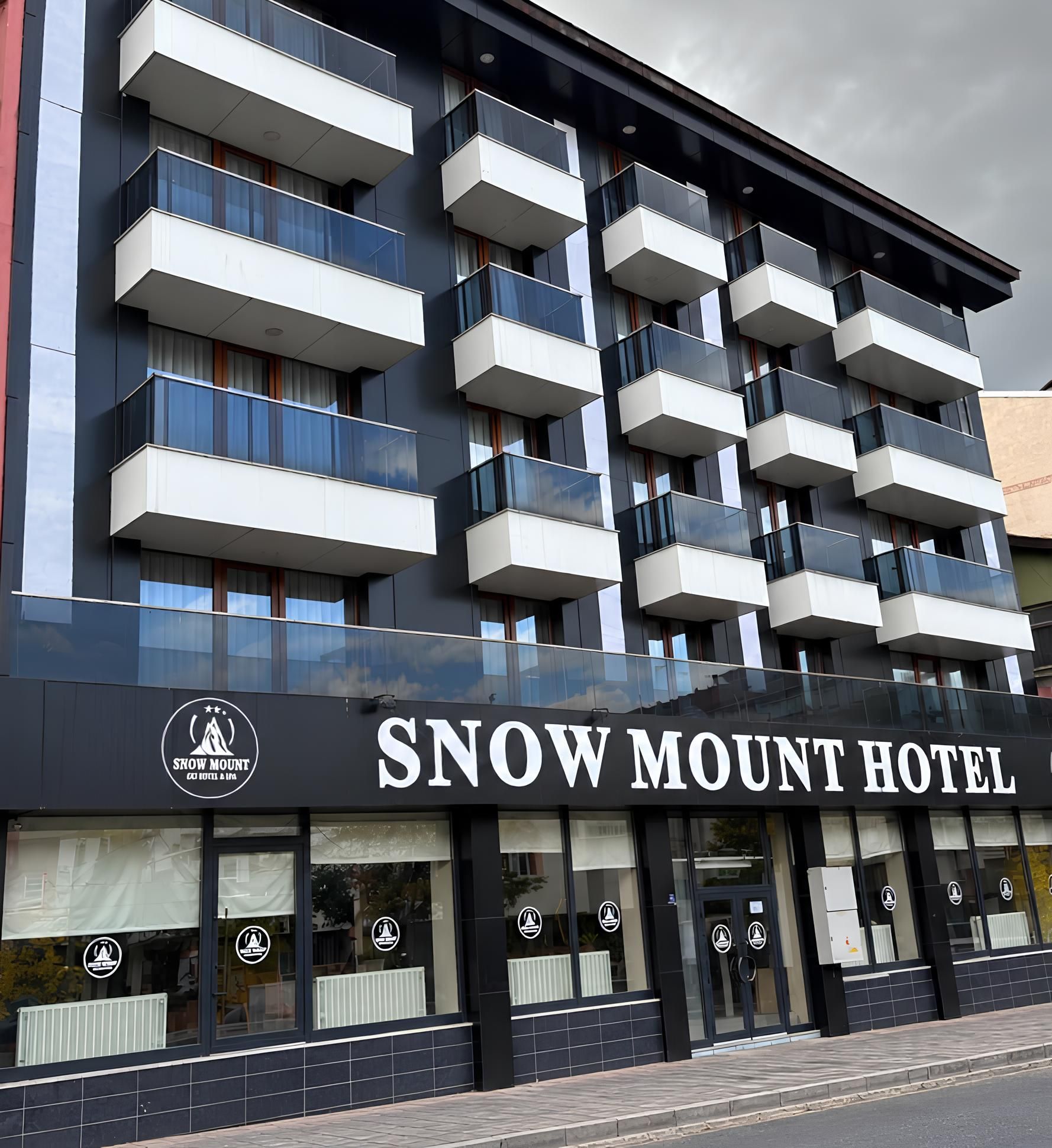 A multi-story hotel with balconies, a prominent signage for 'Snow Mount Hotel,' and a logo indicating it is a hotel and spa.