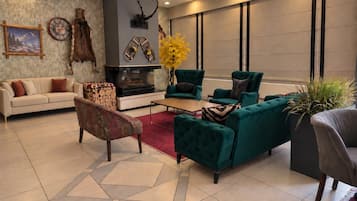 A modern living room with a fireplace, green sofas, a coffee table, and a rug.