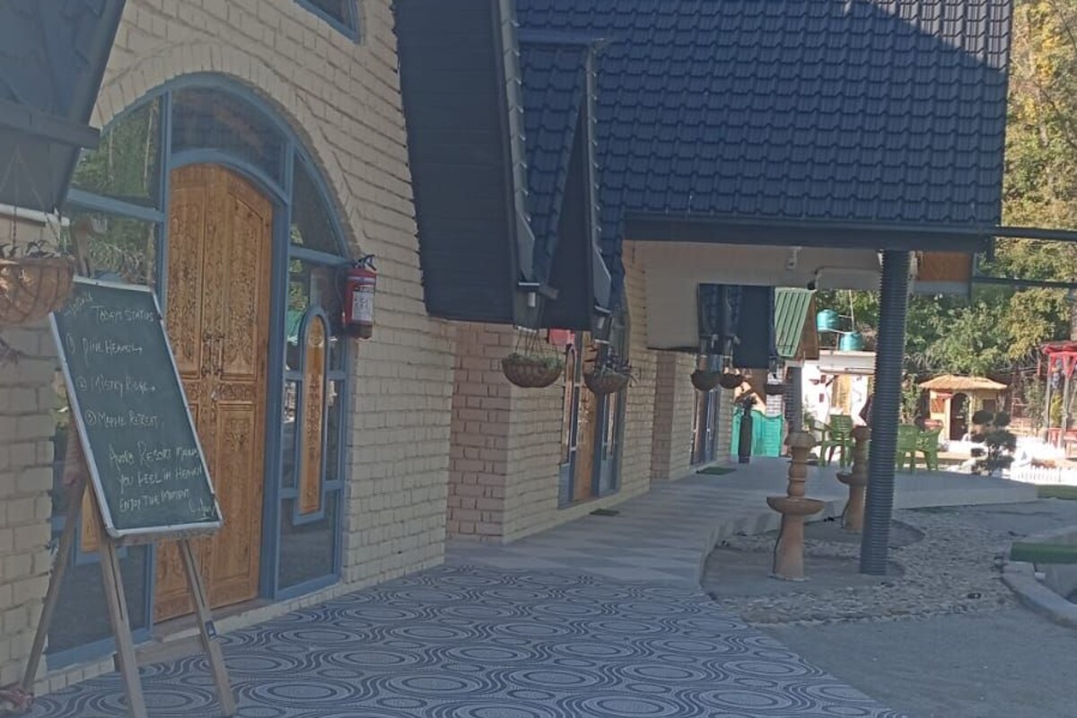 A building with a blue roof, a wooden door, and a patterned floor.