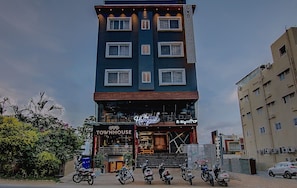 A multi-story building with a sign reading 'OYO TOWNHOUSE' and a restaurant named 'The Hangout' on the ground floor. - Townhouse Global Village Tech Park (Bangalore)